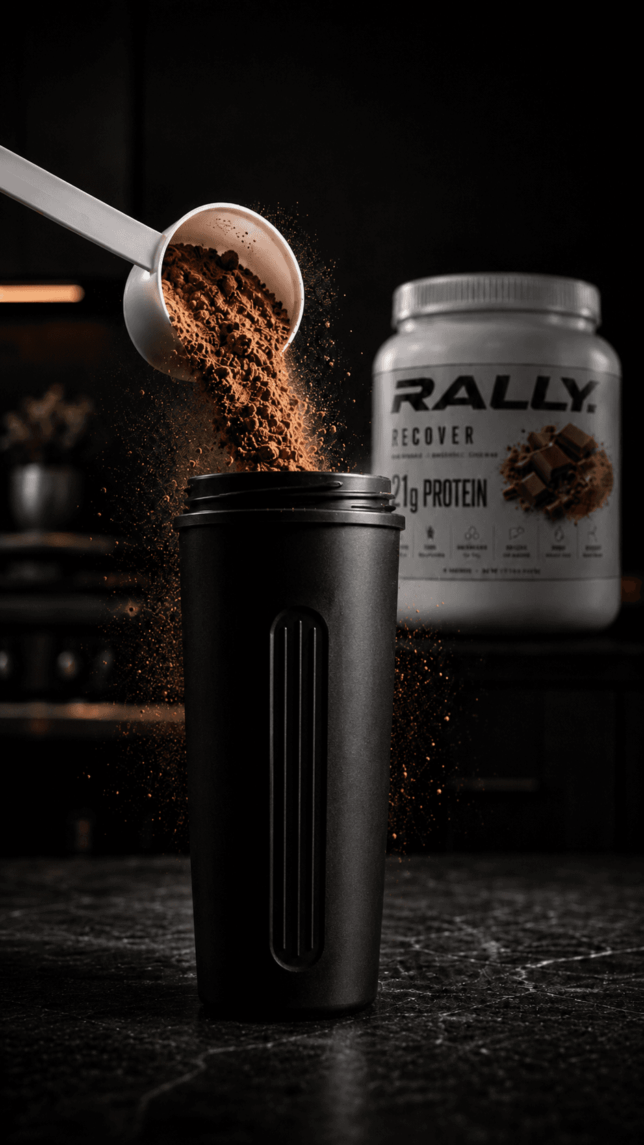 A scoop of RALLY RECOVER powder pouring into a black shaker